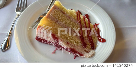 Slice Of Raspberry Layered Cake With Cream Frosting And Drizzle On White Plate Slice Of Raspberry Layered Cake With Cream Frosting And Drizzle On White Plate 141540274