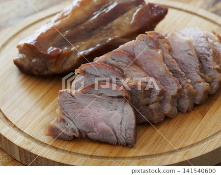 Sliced roast pork on a cutting board 141540600