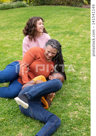 African american family laughing and playing on backyard lawn African american family laughing and playing on backyard lawn 141541149