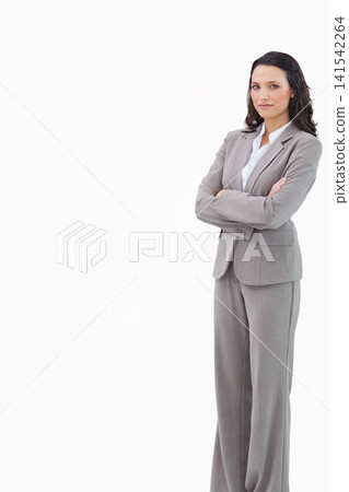 Female professional standing with arms crossed in light gray suit at studio, copy space 141542264