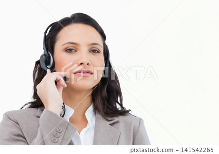 Woman wearing telephone headset and holding boom microphone, speaking in studio with blazer 141542265