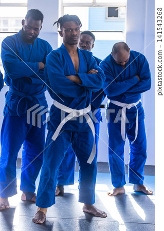 African american men in gis standing confidently on mats at martial arts studio 141543268