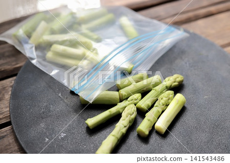 Cut Hokkaido asparagus to put in a freezer bag - homemade frozen vegetables Cut Hokkaido asparagus to put in a freezer bag - homemade frozen vegetables 141543486