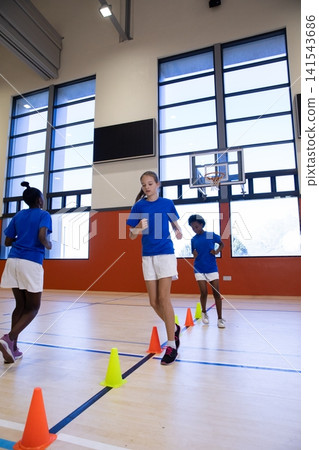 Diverse classmates wearing sportswear running agility drill in school gym Diverse classmates wearing sportswear running agility drill in school gym 141543686