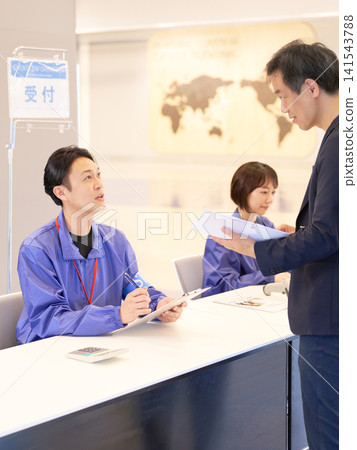 Event staff checking in participants at the reception desk Event staff checking in participants at the reception desk 141543788