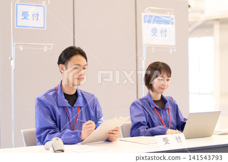 Male and female staff working at the event reception 141543793
