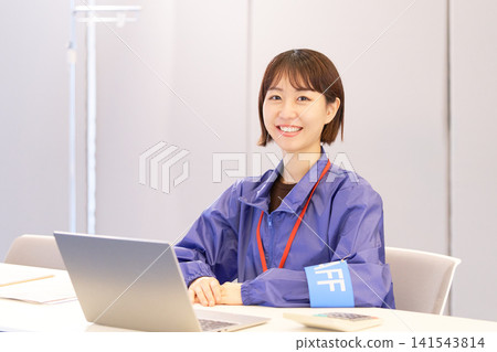 女性工作人員在活動接待處迎接來賓。 女性工作人員在活動接待處迎接來賓。 141543814
