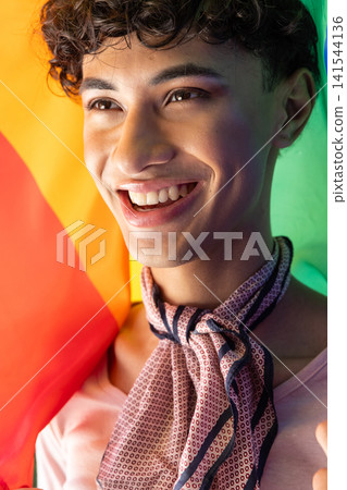 Man holding rainbow pride flag wearing pink t-shirt and scarf Man holding rainbow pride flag wearing pink t-shirt and scarf 141544136