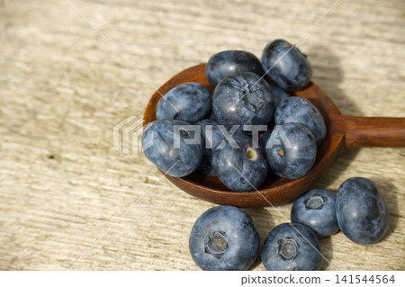 Fresh Blueberries in Wooden Spoon Close-Up Rustic Healthy Summer Berry Snack Still Life Fresh Blueberries in Wooden Spoon Close-Up Rustic Healthy Summer Berry Snack Still Life 141544564