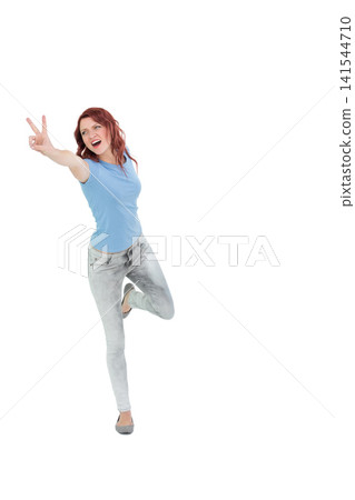 Female posing, balancing on one foot in studio, wearing blue shirt and gray jeans, copy space Female posing, balancing on one foot in studio, wearing blue shirt and gray jeans, copy space 141544710