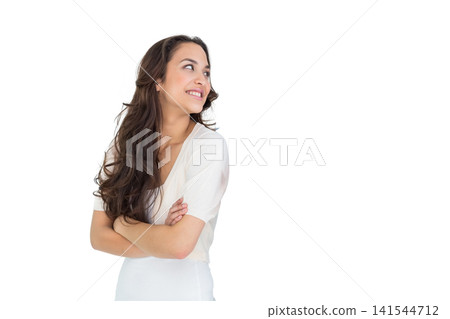 Female standing with arms crossed, smiling and looking up to right in studio with copy space Female standing with arms crossed, smiling and looking up to right in studio with copy space 141544712
