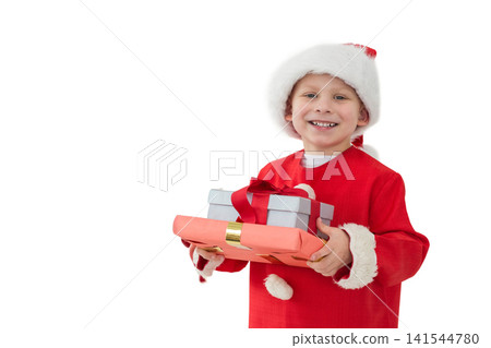 Schoolboy wearing Santa coat and hat, holding red and silver gifts in studio, copy space Schoolboy wearing Santa coat and hat, holding red and silver gifts in studio, copy space 141544780