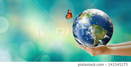 Hand holding earth globe with butterfly flying above it Hand holding earth globe with butterfly flying above it 141545275