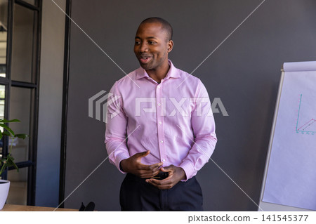African american man presenting line graph on flip chart in meeting room African american man presenting line graph on flip chart in meeting room 141545377