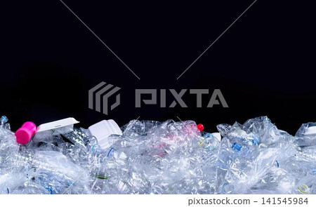 Close-up of colorful plastic trash on snow with black background Close-up of colorful plastic trash on snow with black background 141545984