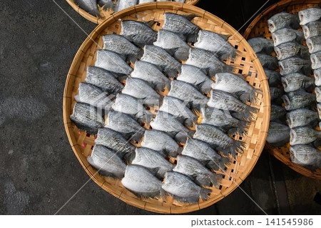 Close-up of dried fish in round wooden basket Close-up of dried fish in round wooden basket 141545986