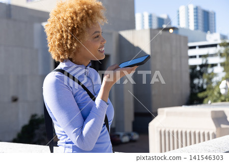 African American woman holding smartphone, wearing purple top and backpack on rooftop, copy space African American woman holding smartphone, wearing purple top and backpack on rooftop, copy space 141546303