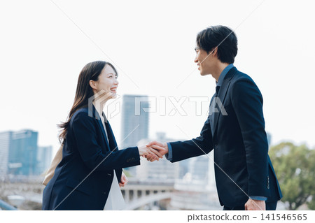 一名女子和一名男子握手，這是商務上的問候。 141546565