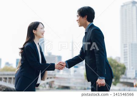 一名女子和一名男子握手，這是商務上的問候。 141546566