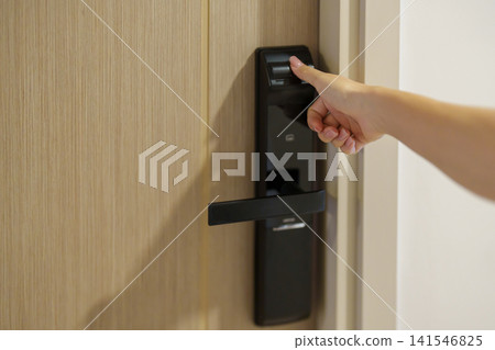 Hand using fingerprint scan for smart digital door lock while open or close the door at home or apartment. NFC Technology, keycard, PIN number, smartphone and contactless lifestyle concepts Hand using fingerprint scan for smart digital door lock while open or close the door at home or apartment. NFC Technology, keycard, PIN number, smartphone and contactless lifestyle concepts 141546825