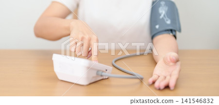 woman checking Blood pressure by Blood pressure monitor with Cuff. Systolic, SYS, Diastolic, DIA, Pulse, Hypertension, Hypotension, Heart rate, Cardiovascular Disease and May World hypertension day 141546832