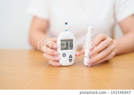 Hand checking Diabetes or Blood glucose self testing by digital blood glucose meter with lancet pen. high blood sugar level, World Diabetes Day, Glycemia, Hypoglycemia, Hyperglycemia and insulin Hand checking Diabetes or Blood glucose self testing by digital blood glucose meter with lancet pen. high blood sugar level, World Diabetes Day, Glycemia, Hypoglycemia, Hyperglycemia and insulin 141546847