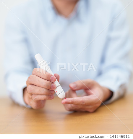 Hand using lancet pen on finger with Blood drop glucose testing or Diabetes checking by digital blood glucose meter. blood sugar level, Diabetes Day, Glycemia, Hypoglycemia, Hyperglycemia and insulin Hand using lancet pen on finger with Blood drop glucose testing or Diabetes checking by digital blood glucose meter. blood sugar level, Diabetes Day, Glycemia, Hypoglycemia, Hyperglycemia and insulin 141546911
