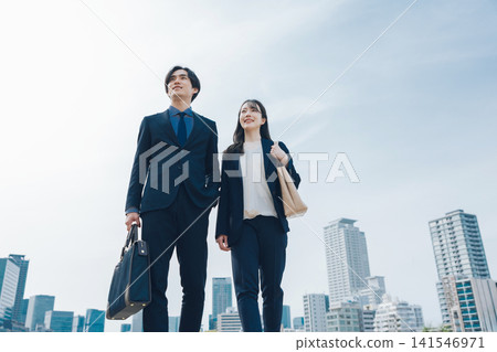 A business scene featuring a man and woman against the backdrop of a city skyline. A business scene featuring a man and woman against the backdrop of a city skyline. 141546971