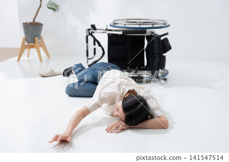 一名坐在輪椅上的女子摔倒了。 一名坐在輪椅上的女子摔倒了。 141547514