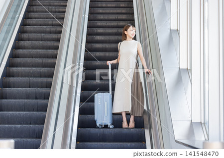 一名女子從自動扶梯下降 141548470