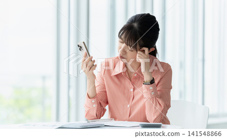 女人/女商人一邊看著智慧型手機一邊思考 女人/女商人一邊看著智慧型手機一邊思考 141548866