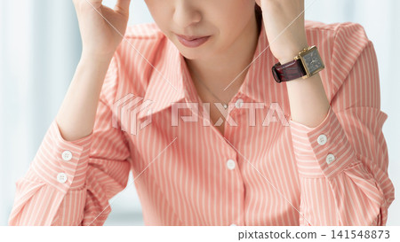 一位憂心忡忡的女人/女商人抱著頭 141548873