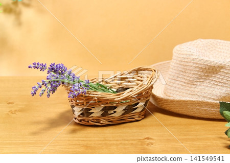 A natural summer image with harvested lavender and a basket, and a straw hat. A natural summer image with harvested lavender and a basket, and a straw hat. 141549541