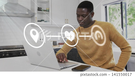 Typing man in mustard sweater using laptop at kitchen island, phone and digital icons, copy space Typing man in mustard sweater using laptop at kitchen island, phone and digital icons, copy space 141550017