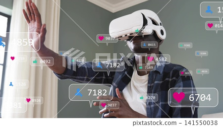 Reaching man in plaid shirt wearing white VR headset at home touching floating hearts, user icons 141550038