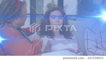 Sitting child on sofa at home, in striped sweater, adult with red headband, blue lens flare 141550053