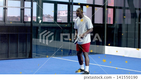 Holding padel racket, man wearing gray T-shirt and red shorts on blue court, copy space Holding padel racket, man wearing gray T-shirt and red shorts on blue court, copy space 141550190
