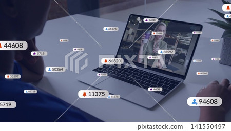 Streaming laptop showing presenter in light-green blouse holding mug on desk, with badges and plant Streaming laptop showing presenter in light-green blouse holding mug on desk, with badges and plant 141550497