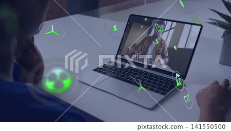 Viewing laptop showing woman presenting in tan jacket at desk, man using mouse, green icons, plant 141550500