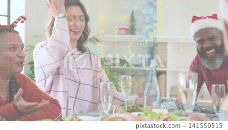 Smiling woman in pink windowpane-check sweater raising hand at dining table, with roast Smiling woman in pink windowpane-check sweater raising hand at dining table, with roast 141550515