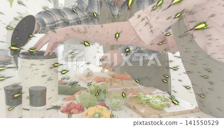 Couple preparing vegetables in home kitchen, woman in pink top, green apron, board, green starburst 141550529