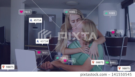 Kissing woman striped top hugging man green T-shirt at kitchen table with laptop and social icons Kissing woman striped top hugging man green T-shirt at kitchen table with laptop and social icons 141550545
