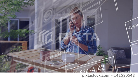 Holding phone, woman wearing plaid shirt stirring paint at back patio with AR overlay, white device Holding phone, woman wearing plaid shirt stirring paint at back patio with AR overlay, white device 141550548