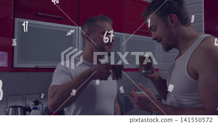 Raising cups, two men in white tee and white tank clinking in home kitchen with kettle Raising cups, two men in white tee and white tank clinking in home kitchen with kettle 141550572