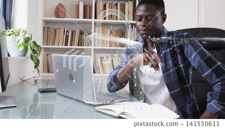 Leaning man in blue plaid overshirt reviewing notes at home office, with laptop padlock hologram Leaning man in blue plaid overshirt reviewing notes at home office, with laptop padlock hologram 141550611