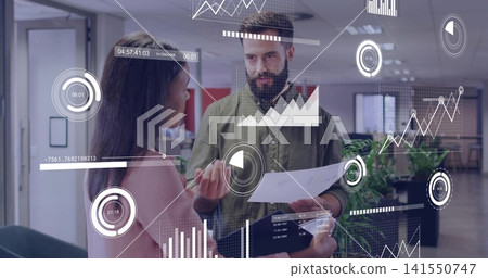 Reviewing pair in green shirt and pink blazer studying documents in open office with data overlays Reviewing pair in green shirt and pink blazer studying documents in open office with data overlays 141550747