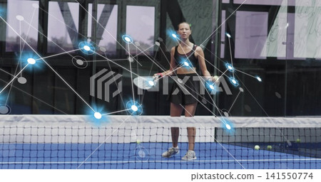 Standing woman holding paddle on blue court with digital overlay, wearing black outfit and sneakers Standing woman holding paddle on blue court with digital overlay, wearing black outfit and sneakers 141550774