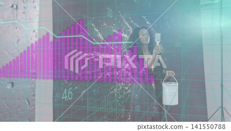 Holding paint bucket, smocked woman raising brush in studio with paint splash and magenta overlay Holding paint bucket, smocked woman raising brush in studio with paint splash and magenta overlay 141550788