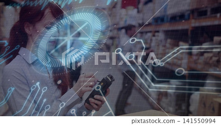 Scanning female worker in light shirt long-sleeve using mobile scanner in warehouse HUD, copy space Scanning female worker in light shirt long-sleeve using mobile scanner in warehouse HUD, copy space 141550994