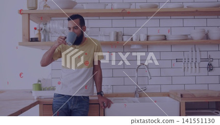 Drinking man in yellow-striped tee and jeans leaning on counter in home kitchen, holding grey mug Drinking man in yellow-striped tee and jeans leaning on counter in home kitchen, holding grey mug 141551130